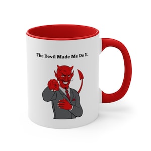 May include: White ceramic mug with a red rim and handle. The mug features a cartoon image of a red devil in a suit pointing at the viewer with the text "The Devil Made Me Do It."