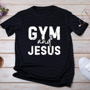 May include: Black t-shirt with white text that reads 'GYM and JESUS'.