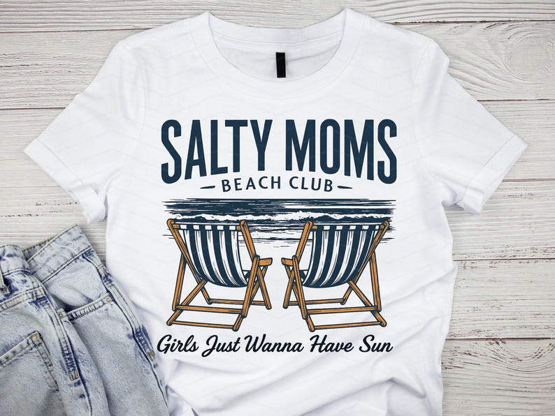 May include: White t-shirt with a blue graphic that says "Salty Moms Beach Club" and features two beach chairs with a blue and white striped design. The text "Girls Just Wanna Have Sun" is below the chairs.