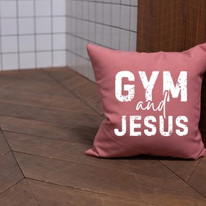 May include: A pink throw pillow with the text "GYM and JESUS" in white lettering.