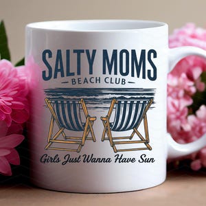 May include: White ceramic mug featuring a design of two deckchairs and the text "Salty Moms Beach Club - Girls Just Wanna Have Sun".