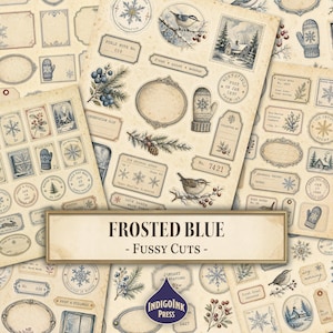 May include: A collection of vintage-style paper ephemera featuring winter motifs including snowflakes, mittens, birds, pine branches, and berries. The sheet contains various labels, frames, and stamps with text like FROSTED BLUE - FUSSY CUTS and INDIGOINK PRESS.
