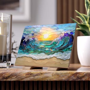 May include: A stained glass panel depicting a seascape with a setting sun and crashing waves. The artwork features shades of blue, green, and yellow, with a sandy beach at the bottom. The panel is displayed on a wooden stand.