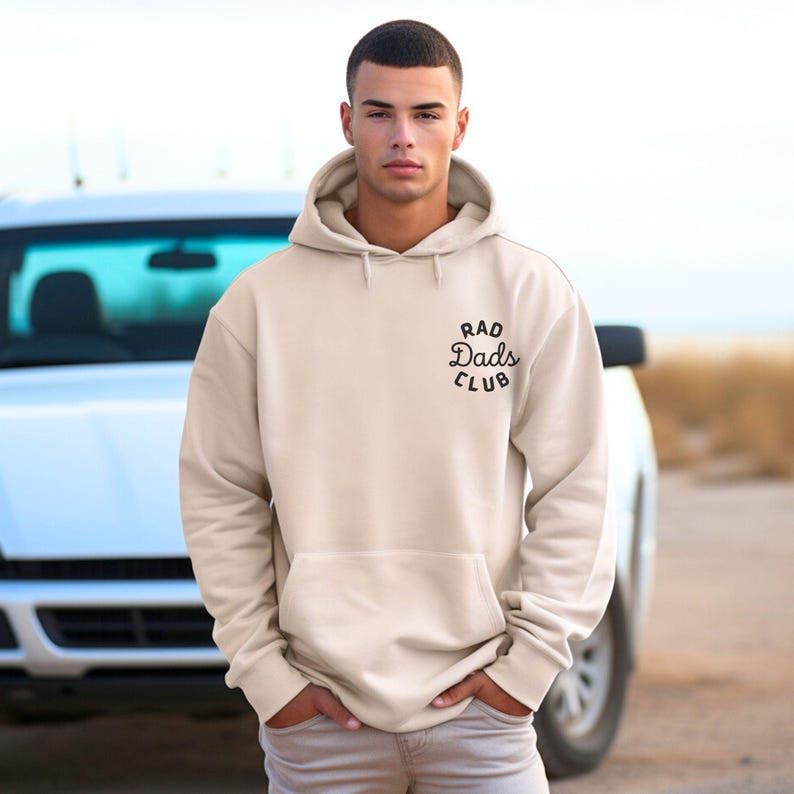 May include: A beige hoodie with a black embroidered logo that says "Rad Dads Club".