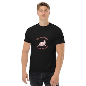 May include: Black t-shirt featuring a pink blobfish illustration and the text "The ground is my ocean".