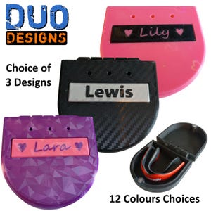 May include: Three personalised mouthguard cases are displayed in pink, black, and purple, each with a name. The cases are in different designs, with the text "Choice of 3 Designs" visible. A black case with a red and white mouthguard is also shown. The text "12 Colours Choices" is also visible.