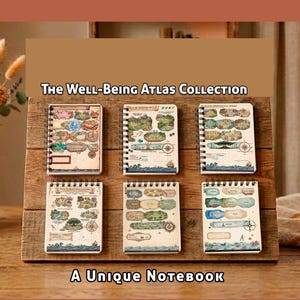 Puede incluir: Seis cuadernos con espiral con diseños de mapas ilustrados se exhiben en un soporte de madera. Los cuadernos presentan dibujos coloridos de paisajes, monumentos y elementos náuticos. El texto "The Well-Being Atlas Collection" y "A Unique Notebook" es visible.