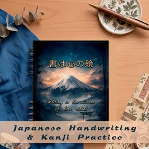 Puede incluir: Un cuaderno con espiral con una portada que presenta un paisaje montañoso bajo un cielo estrellado. La portada incluye texto japonés y la frase en inglés "Writing is the mirror of the soul". El cuaderno está etiquetado como "Japanese Handwriting & Kanji Practice".