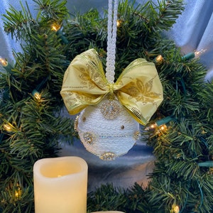 White brocade Ornament studded with sparkling rhinestones and a glittery gold bow.