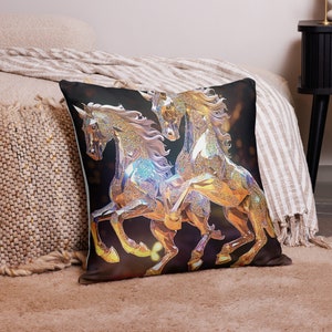 May include: Square cushion with a digital artwork of two horses in gold, silver, and iridescent hues. The horses are set against a dark backdrop. The cushion is placed on a bed with a neutral-toned blanket and rug, creating a cozy atmosphere.