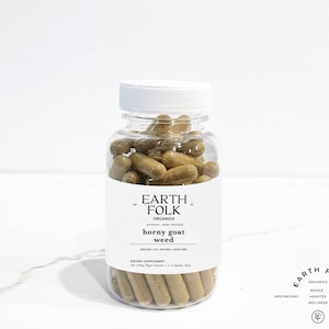 Könnte beinhalten: Eine durchsichtige Plastikflasche gefüllt mit braunen Kapseln mit der Aufschrift "EARTH FOLK ORGANICS horny goat weed". Die Flasche steht auf einer weißen Marmorfläche.