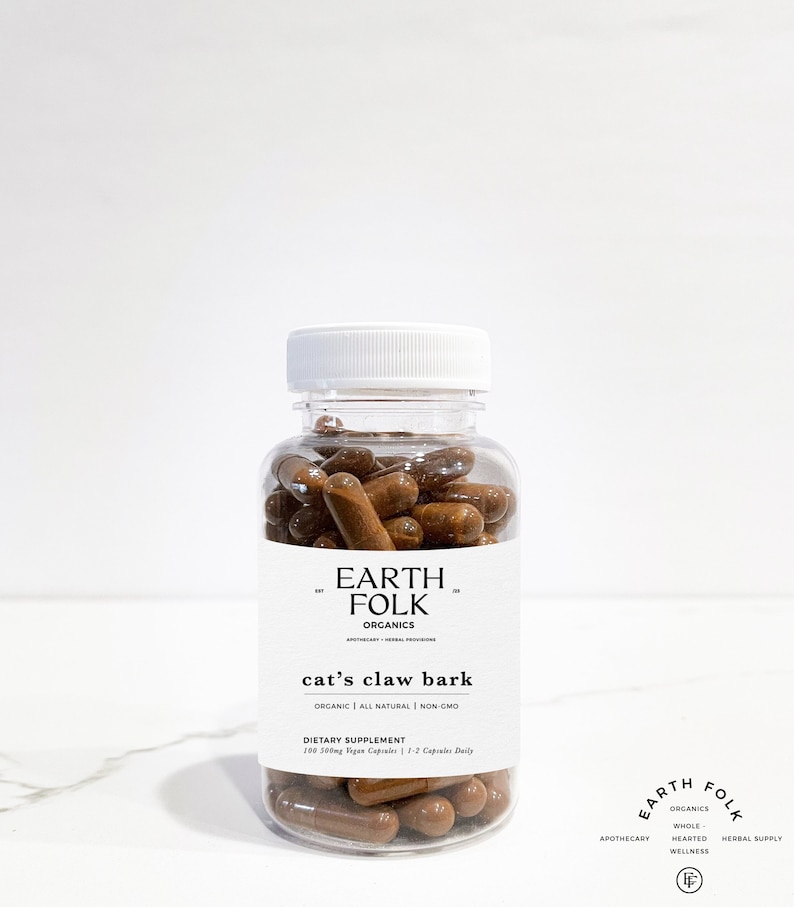 May include: A clear plastic bottle filled with brown capsules labeled "EARTH FOLK ORGANICS cat's claw bark ORGANIC | ALL NATURAL | NON-GMO DIETARY SUPPLEMENT 100 500mg Vegan Capsules | 1-2 Capsules Daily"