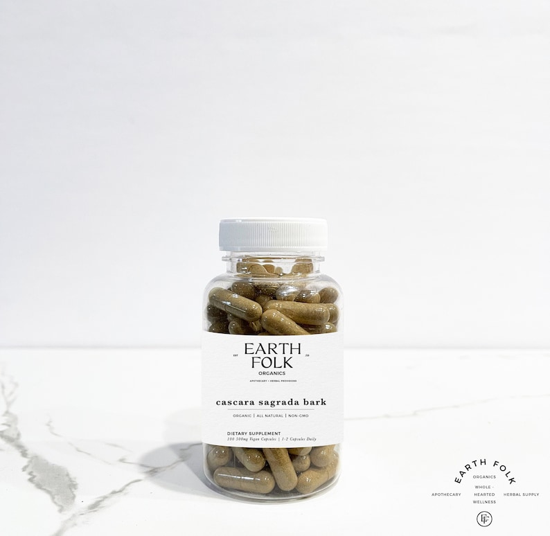 May include: A clear plastic bottle filled with brown capsules labeled "EARTH FOLK ORGANICS cascara sagrada bark ORGANIC | ALL NATURAL | NON GMO DIETARY SUPPLEMENT 100 200mg Vegan Capsules | 1-2 Capsules Daily"