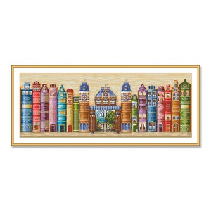 May include: A colorful cross-stitch pattern depicting a row of houses made of books. The houses are in various colors and styles, with some having windows and doors. The houses are arranged in a row on a wooden background.