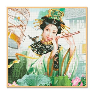 Könnte beinhalten: Kreuzstich einer Frau in traditioneller asiatischer Kleidung, die Flöte spielt. Sie trägt ein grün-schwarzes, besticktes Gewand und einen juwelenbesetzten Kopfschmuck. Ein kleiner Vogel sitzt auf ihrer Schulter, und ein Vogelkäfig ist im Hintergrund. Das Kunstwerk ist gerahmt.