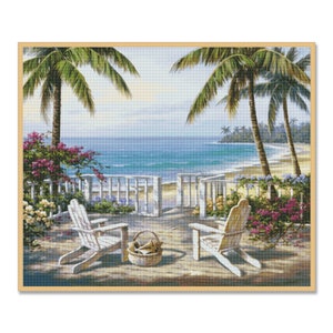 May include: Two white wooden chairs sit on a wooden deck overlooking a beach with blue water and palm trees. A basket of seashells sits on the deck between the chairs.