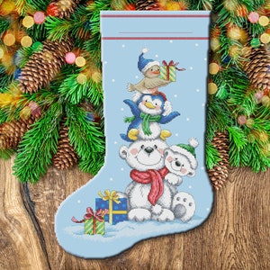 May include: A blue Christmas stocking with a white polar bear, penguin, and bird holding presents. The stocking is decorated with a white snowflake pattern.