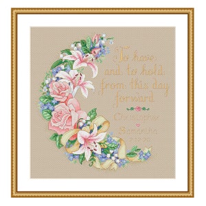 May include: Cross-stitch pattern featuring a floral wreath with lilies, roses, and forget-me-nots. The wreath is in the shape of a crescent moon. The text "To have and to hold from this day forward" is written in gold script.