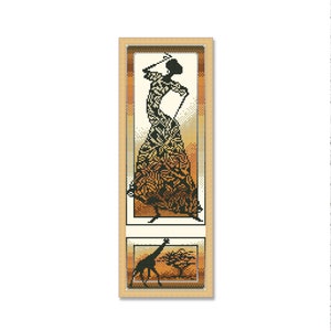 May include: A framed cross-stitch design featuring a silhouette of a woman in a patterned dress and a giraffe with a tree in the background. The design is in shades of brown, orange, and black.