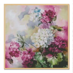 May include: A framed cross-stitch floral design featuring clusters of white, pink, and burgundy flowers with green leaves. The background has soft watercolor-like hues of pink, yellow, and blue. The artwork is in a wooden frame.
