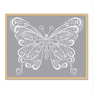 May include: A white butterfly with intricate details is framed against a gray background.
