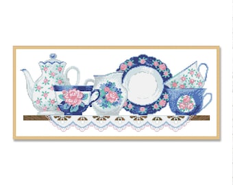 May include: A set of blue and white teacups and teapot with pink floral designs, arranged on a shelf with a lace doily.
