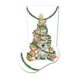 Può includere: Un calzino di Natale bianco con una ghirlanda verde e un albero di Natale fatto di animali. Gli animali sono un gatto, un cane, un procione, un coniglio e un criceto. Gli animali indossano tutti bastoncini di zucchero.