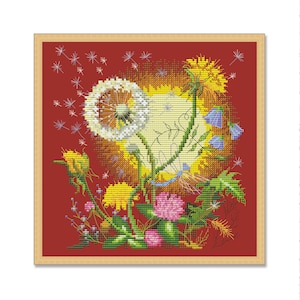 Puede incluir: Una bordado de punto de cruz de un ramo de dientes de león con flores blancas, amarillas y verdes sobre un fondo rojo.
