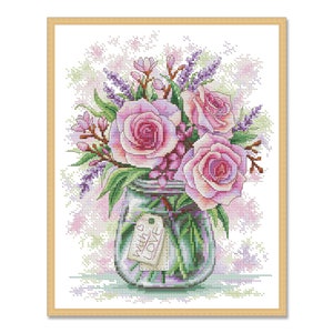 May include: A cross-stitch pattern of a glass jar filled with pink roses, lavender, and other flowers. The jar has a tag that reads "Always Love".