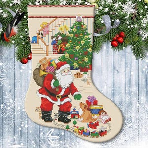 May include: A festive Christmas stocking with a cross-stitch design. It shows Santa Claus with a sack of toys, a decorated Christmas tree, and children. The colour scheme includes red, green, and beige.