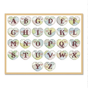 Könnte beinhalten: Ein farbenfroher Alphabet-Chart mit jedem Buchstaben in einer Patchwork-Herzform. Die Buchstaben sind in Braun und die Herzen sind in Grün-, Blau-, Gelb- und Rosatönen.