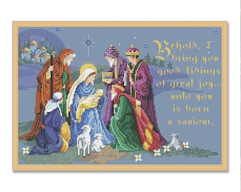 May include: Cross-stitch depiction of the Nativity scene, featuring Mary, Joseph, baby Jesus, and the Three Wise Men. The artwork is framed in a light wood tone, with a blue background and text that reads "Behold, I bring you good tidings of great joy... unto you is born a savior."
