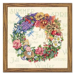 Op de afbeelding: Een kleurrijke bloemenkrans met verschillende bloemen, bladeren en bessen. De krans is omringd door de woorden "Summer", "Winter", "Spring" en "Fall" in een cirkelvorm.
