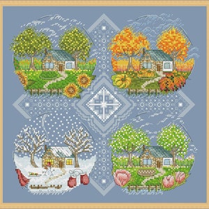 May include: A cross-stitch artwork depicting four seasonal scenes: spring, summer, autumn, and winter. Each scene features a house, trees, and seasonal elements like sunflowers, pumpkins, and snow. The artwork is framed in a light blue border.