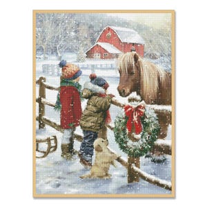 Peut inclure: Deux enfants vêtus d'habits d'hiver se tiennent près d'une clôture en bois avec un poney brun et une couronne de Noël. Un petit chiot blanc se tient devant eux. Une grange rouge se trouve en arrière-plan.