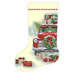 May include: A red vintage truck with a wreath on the front bumper is filled with Christmas presents. The truck is driving through a snowy scene. The image is on a cream-colored stocking with a red and white striped cuff.