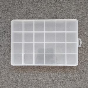 May include: A clear plastic storage box with 16 compartments. The box has a hinged lid and a small handle on the side.