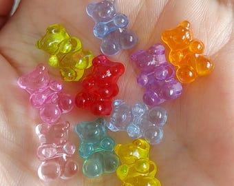 May include: Assortment of colorful gummy bear charms in various colors, including pink, red, orange, yellow, green, blue, and purple. The charms are shaped like teddy bears and are made of clear plastic.