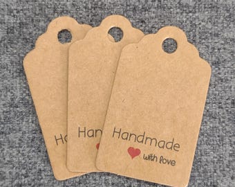 May include: Three brown paper gift tags with scalloped edges and a hole at the top. The tag on the right has the text "Handmade with love" and a red heart.