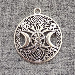 May include: Silver pendant featuring a Celtic knot design with a tree of life, triple moon, and pentagram.