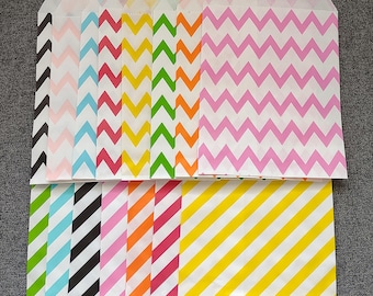 May include: A collection of colorful paper treat bags with various chevron and diagonal stripe patterns. The bags feature a range of colors, including pink, blue, green, yellow, orange, and black, perfect for party favors or small gifts.