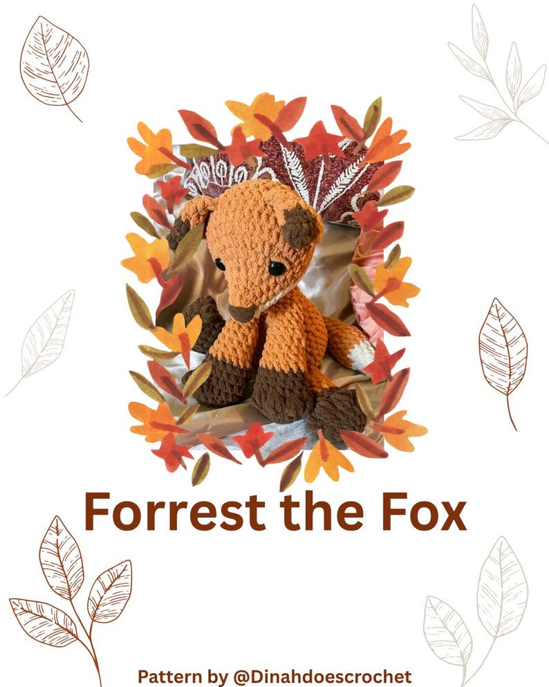 May include: A crocheted fox toy with orange and brown yarn, sitting amidst autumn leaves. The fox has dark brown paws and a white-tipped tail. The text "Forrest the Fox" is displayed below the fox.