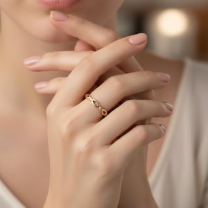 Peut inclure: Une bague en or composée d'une série de maillons en forme de marquise interconnectés. Chaque maillon est séparé par une petite pierre précieuse ronde et transparente sertie sur l'anneau. La bague présente une finition métallique polie.