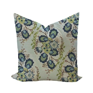 May include: A light blue cushion with a floral pattern in shades of green, blue, and white. The cushion features a paisley-inspired design with intricate details.