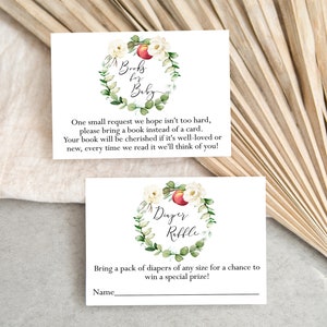 May include: Two white cards with floral wreaths and text. The top card says "Books for Baby" and asks guests to bring a book instead of a card. The bottom card says "Diaper Raffle" and asks guests to bring a pack of diapers for a chance to win a prize.