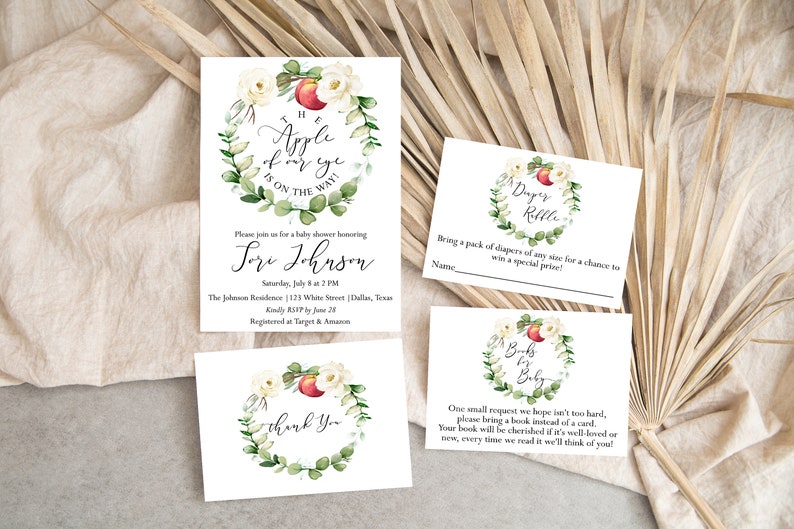 May include: A set of three white cards with watercolor illustrations of a peach and floral wreath. The text on the cards reads "The apple of my eye is on the way!"  "Please join us for a baby shower honoring Lori Johnson", "Diaper Raffle", and "Books for Baby".