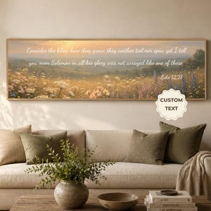 May include: A panoramic landscape wall art print featuring a sunlit meadow of wildflowers under a soft sky. The text reads: Consider the lilies, how they grow; they neither toil nor spin, yet I tell you, even Solomon in all his glory was not arrayed like one of these. Luke 12:27.