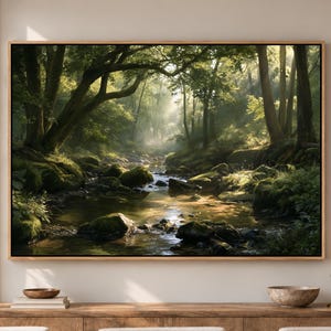 May include: A rectangular wall art print featuring a lush forest landscape with a flowing stream, moss-covered rocks, and dense green trees. Sunlight filters through the canopy, creating light rays and shadows across the water and forest floor.