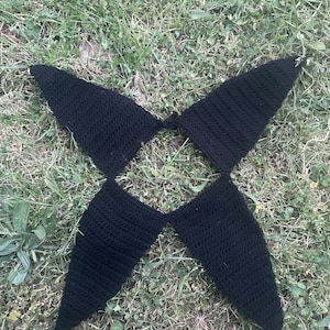 May include: Black crocheted halter top with a geometric design. The top is made of a soft, textured yarn and has a loose, flowy fit.
