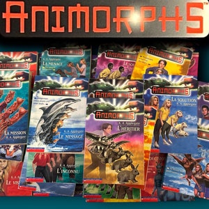 Puede incluir: Una colección de libros de Animorphs de K.A. Applegate, con portadas que muestran niños y animales. El título "Animorphs" está en naranja. Algunos libros tienen títulos en francés. Los libros están apilados.